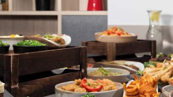 A buffet table with various dishes and plates.