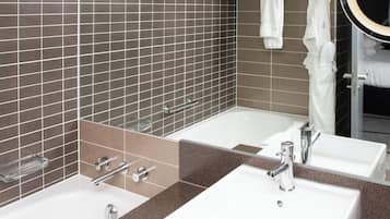 Een badkamer met twee wasbakken, een spiegel en een handdoekhouder.