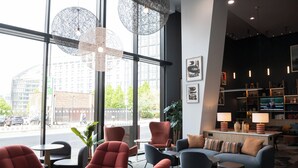 Ein modernes Interieur mit großen Fenstern, Sitzbereichen und einer Bar.