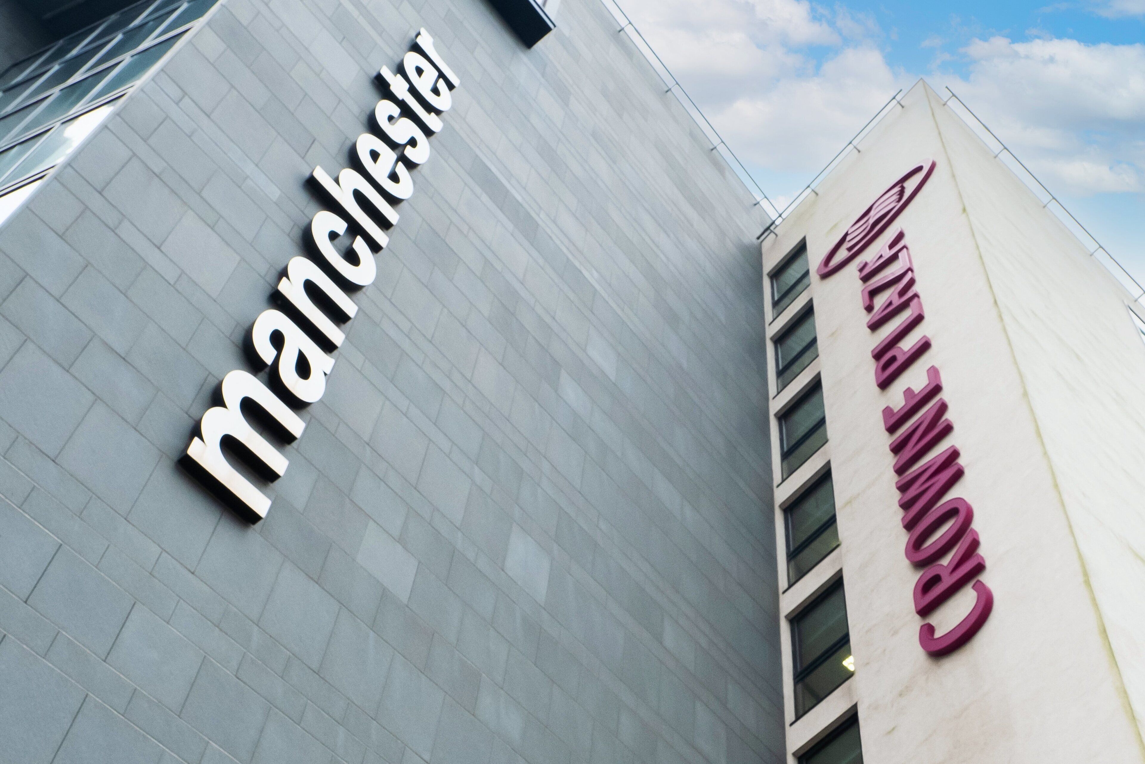 A building with the text 'Manchester' and 'Crowne Plaza' on its facade.