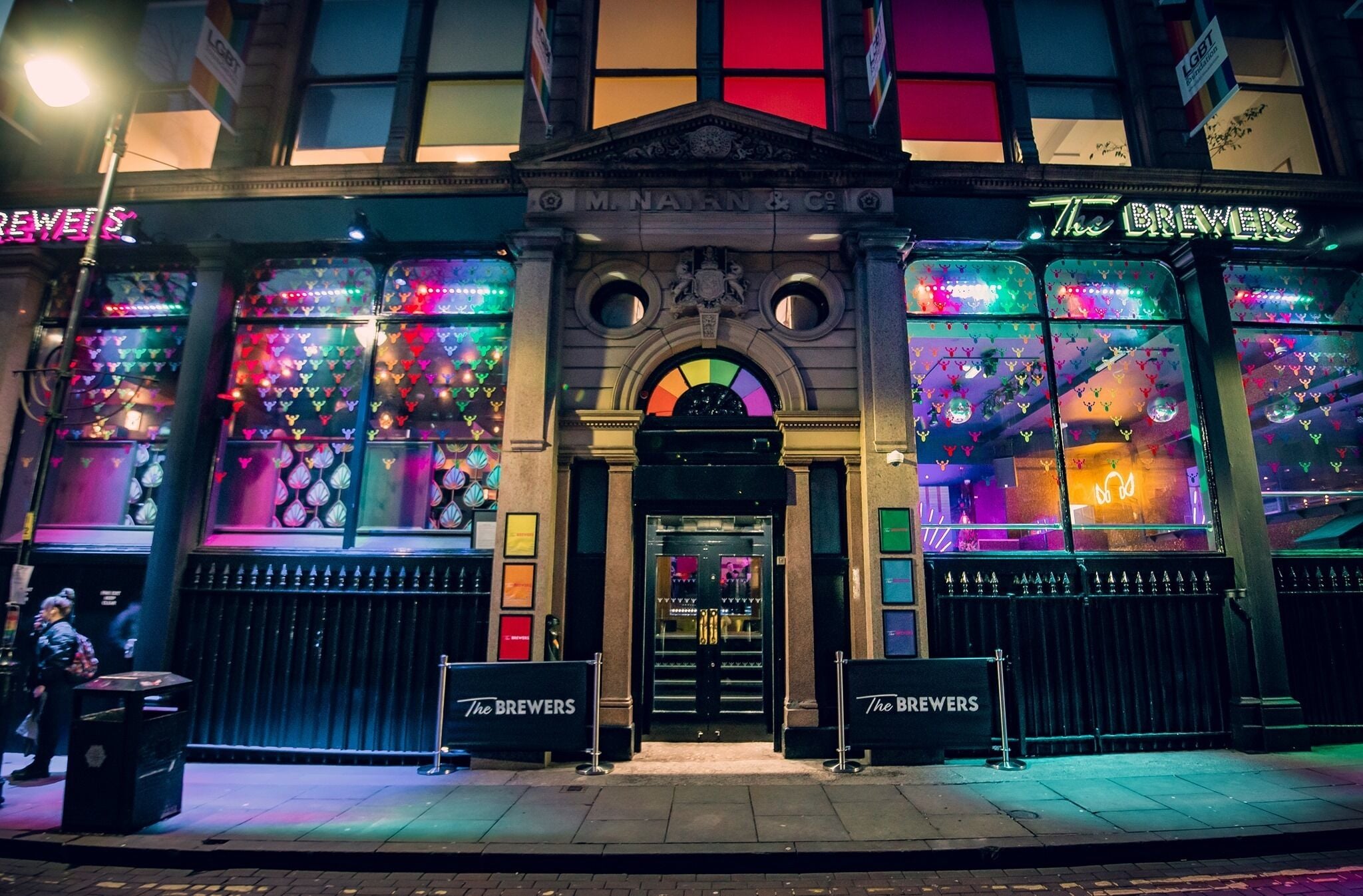A building with a prominent sign reading "The Brewers" and a colorful window display.