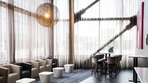 Ein modernes Interieur mit einer Sitzecke, einer Treppe und großen Fenstern.