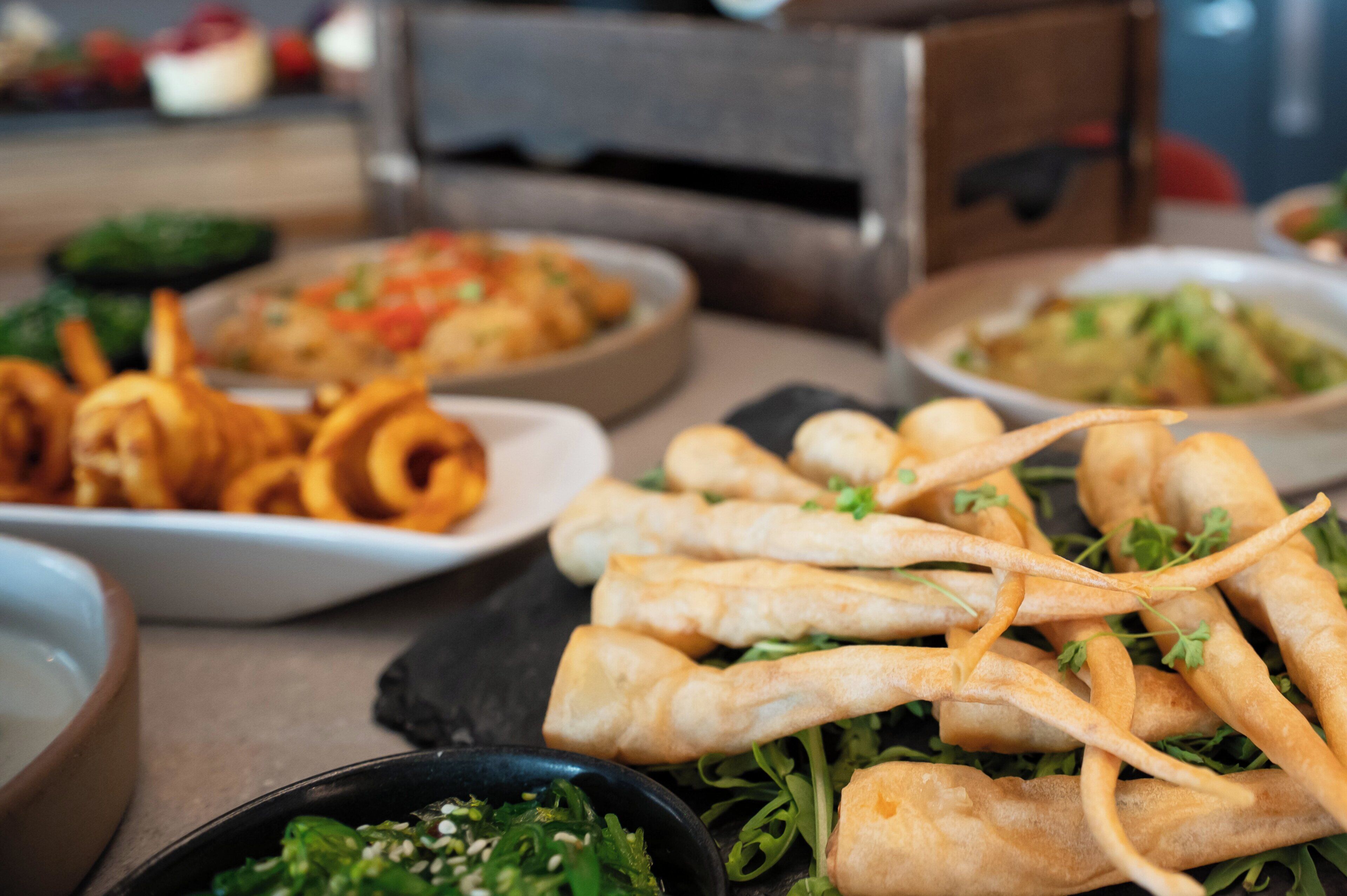 A variety of dishes including fried items and salads on a table.