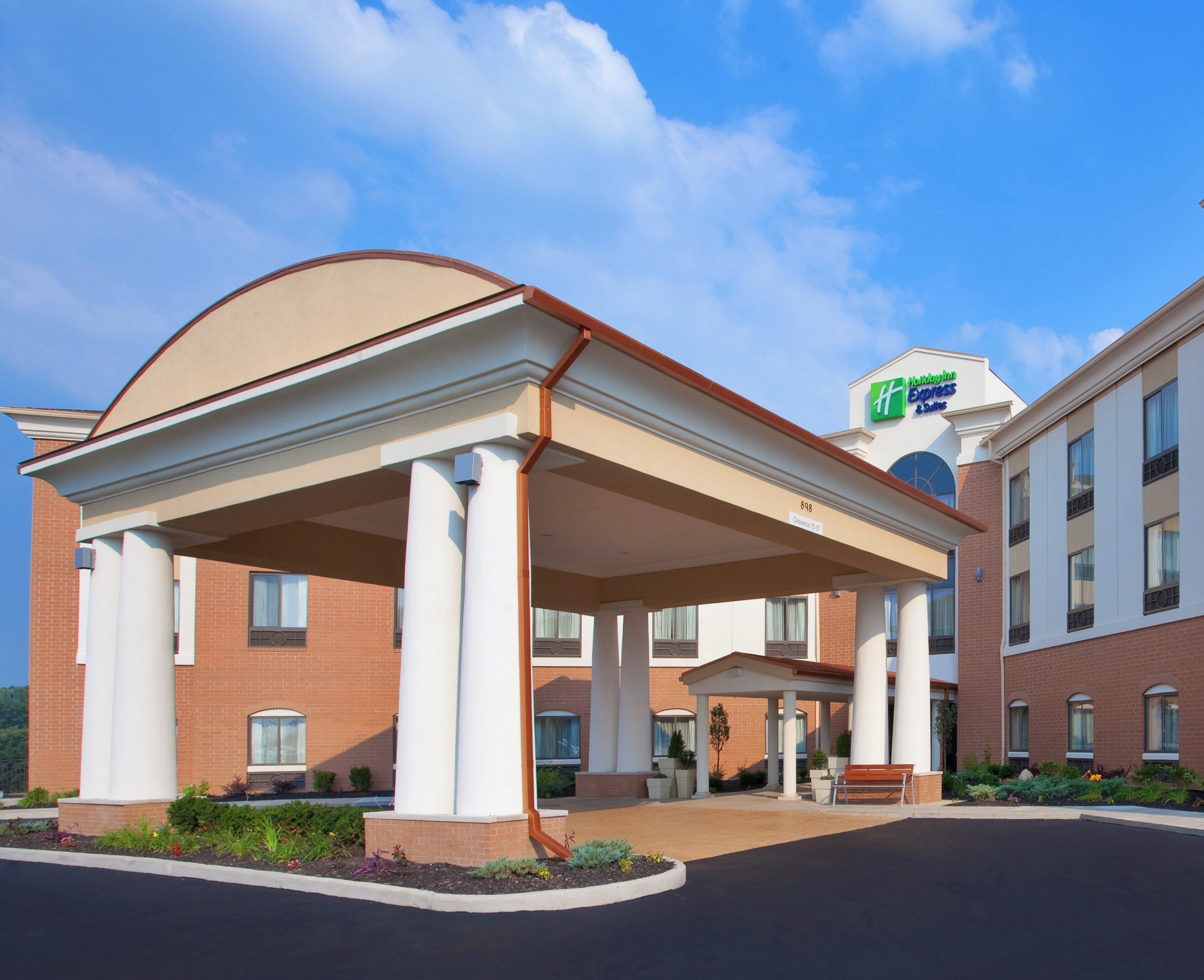 Ein Hotel mit überdachtem Eingang, blauem Himmel und einem Schild für Holiday Inn Express Suites.