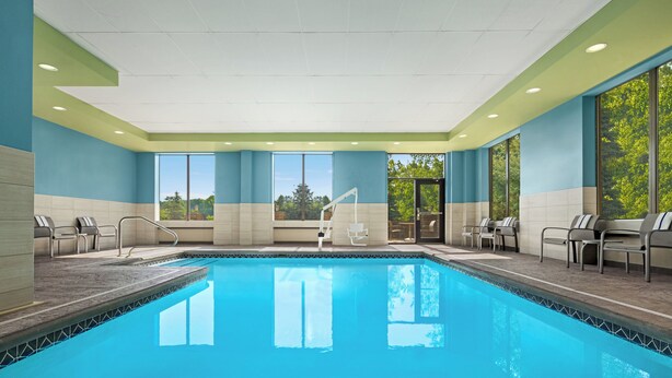 A swimming pool with chairs and a changing room. - Holiday Inn Express & Suites Akron Regional Airport Area by IHG (Akron)