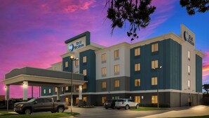 A hotel with a modern design, featuring a covered parking area and multiple floors.
