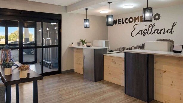 A reception area with a 'WELCOME Eastland' sign, a reception desk, and a window view of a parking lot.