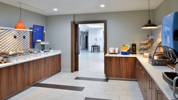 A modern kitchen with wooden cabinets, a central island, and a breakfast bar.