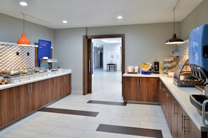 A modern kitchen with wooden cabinets, a central island, and a breakfast bar. - Holiday Inn Express & Suites Carthage by IHG (Carthage)