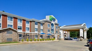 A hotel with a stone facade, multiple windows, and a covered entrance.