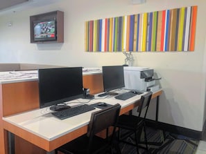 A workspace with two computer monitors, a printer, and a television mounted on the wall. - Holiday Inn Express & Suites Hearne by IHG (Hearne)