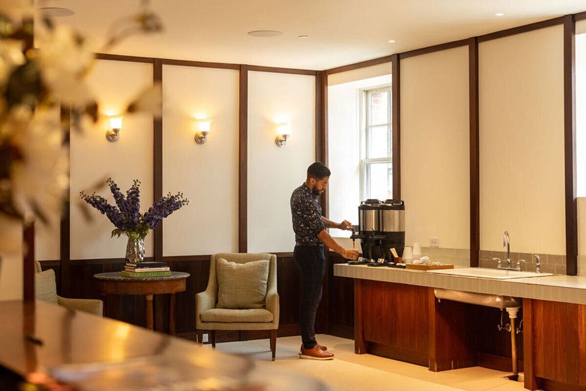 A modern kitchen with a built-in coffee machine, a sink, and a window providing natural light.