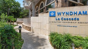 A sign for Wyndham La Cascada, a vacation ownership resort, with a stone wall and arched windows. - Club Wyndham La Cascada (San Antonio)
