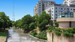 A river running through a park with buildings on one side. - Club Wyndham La Cascada (San Antonio)