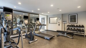 A gym with treadmills, elliptical machines, and a bench. - Candlewood Suites Bluffton-Hilton Head by IHG (Bluffton)