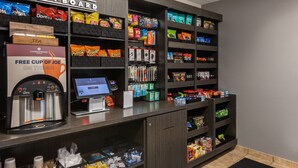A self-service kiosk with snacks, a coffee machine, and a free cup offer sign. - Candlewood Suites Bluffton-Hilton Head by IHG (Bluffton)