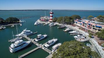 Un port de plaisance où sont amarrés de nombreux bateaux, un phare et un bâtiment doté d’un toit rouge.