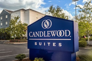 Une enseigne pour Candlewood Suites, au design moderne, avec un logo et le nom de l’établissement mis en évidence.