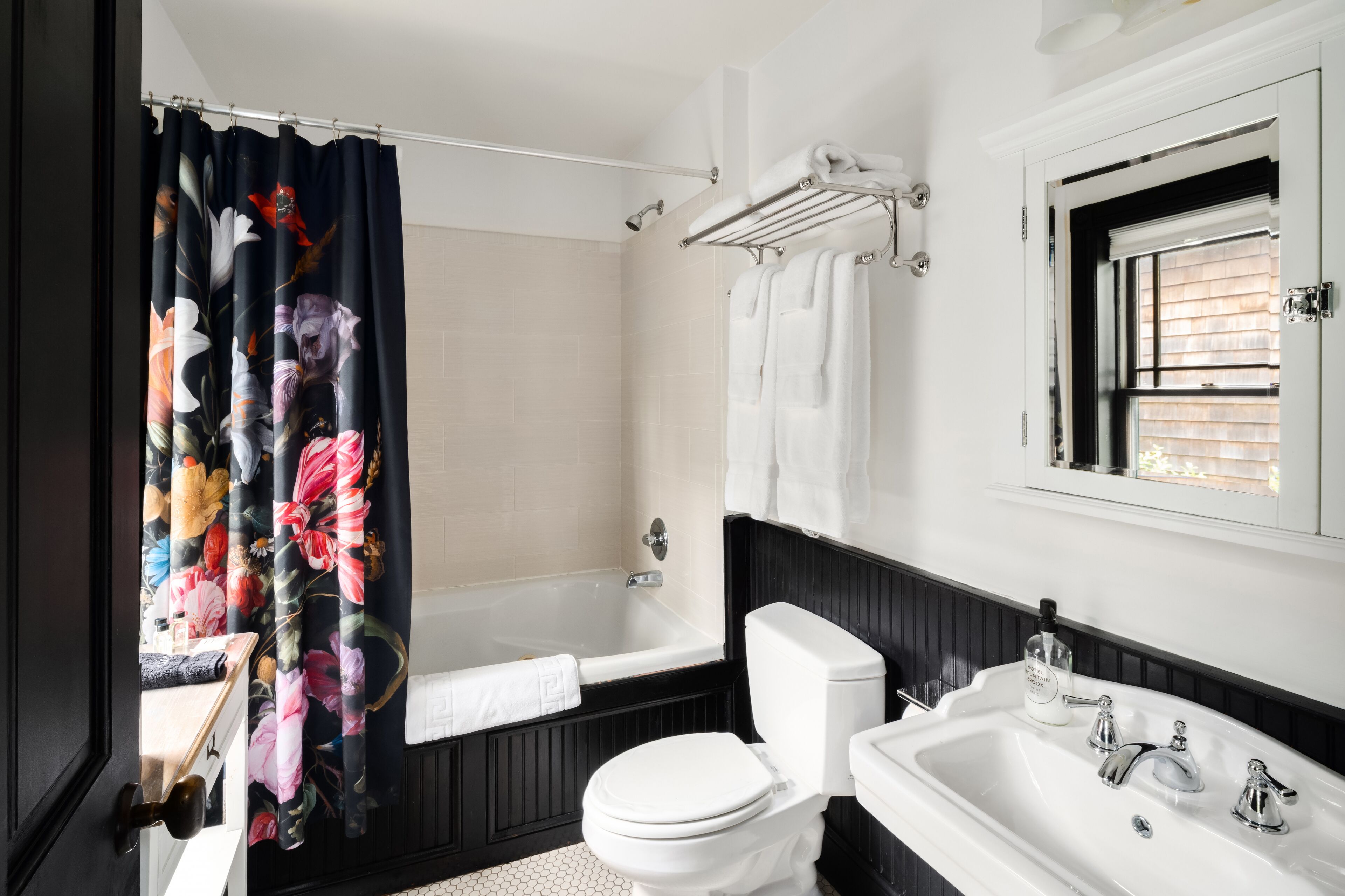A bathroom with a bathtub, toilet, and sink.