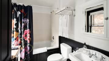 A bathroom with a bathtub, toilet, and sink.
