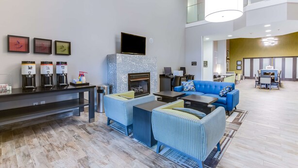 Un vestíbulo moderno con chimenea, zona de estar y mostrador de recepción.