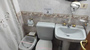 A bathroom with a toilet, bidet, and sink, all marked with red tape indicating disinfection.