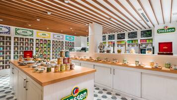 Una tienda de té Stassen con techo de madera, estanterías llenas de botes de té y un mostrador que exhibe productos de té.