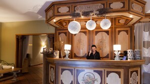 A reception desk with a wooden design, a mirror, and a telephone. - The Originals Relais, Le Verger des Châteaux (Dieffenthal)