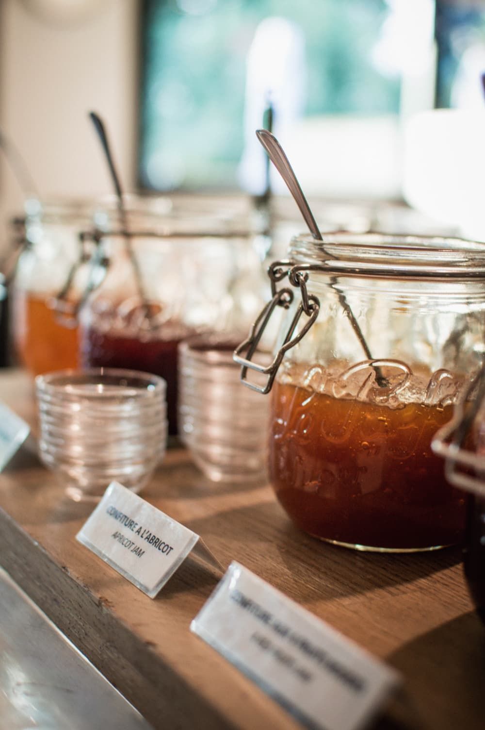 A wooden counter with jars of jam and a sign indicating 'Confiture à l'abricot'.