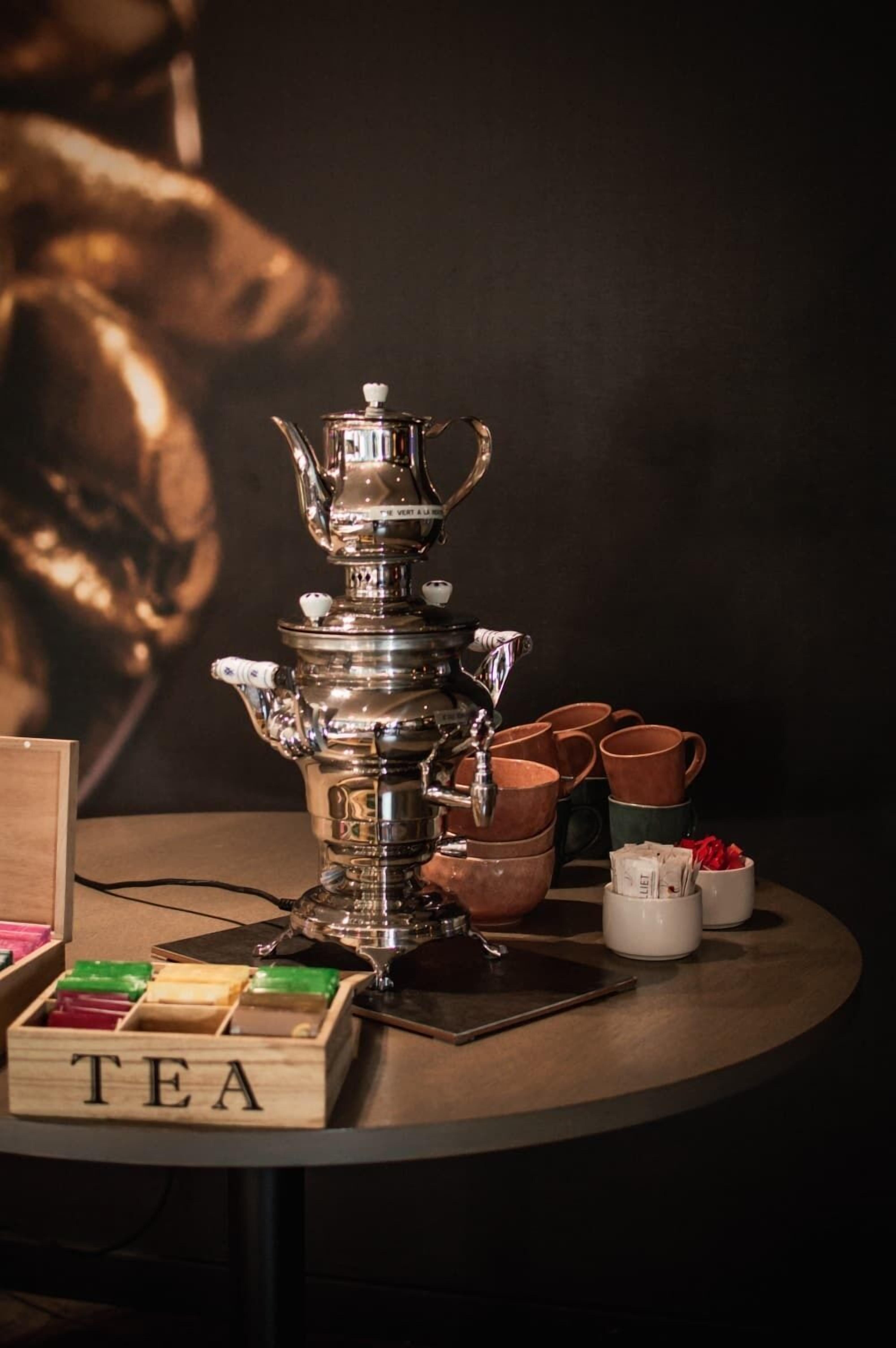 A traditional tea set with multiple cups and a teapot on a table.