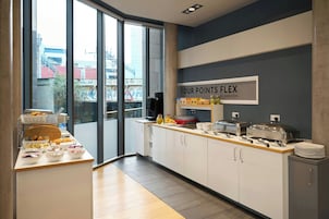Cocina moderna con una barra de buffet, un ventanal amplio y un cartel que dice 'FOUR POINTS FLEX BY SHERATON'.