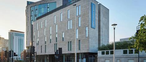 A modern building with a prominent 'FOUR POINTS FLEX' sign, large windows, and a flat roof.