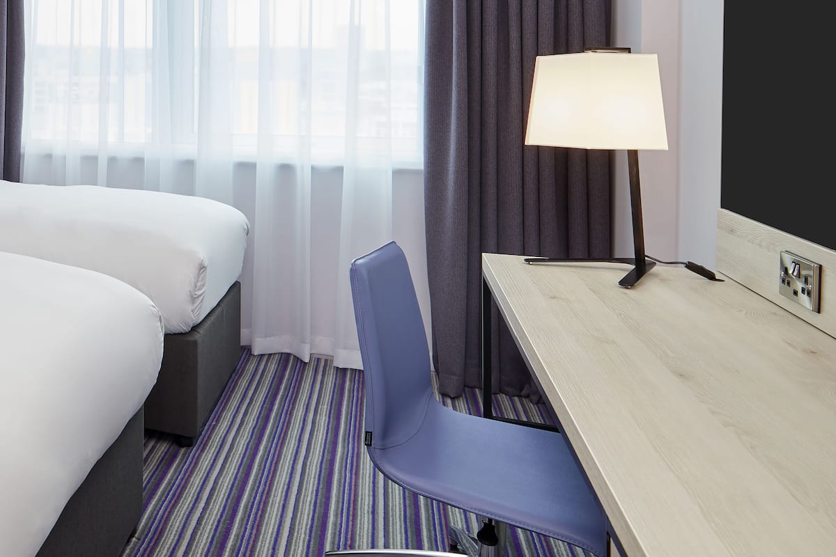 Escritorio, cortinas blackout y tabla de planchar con plancha