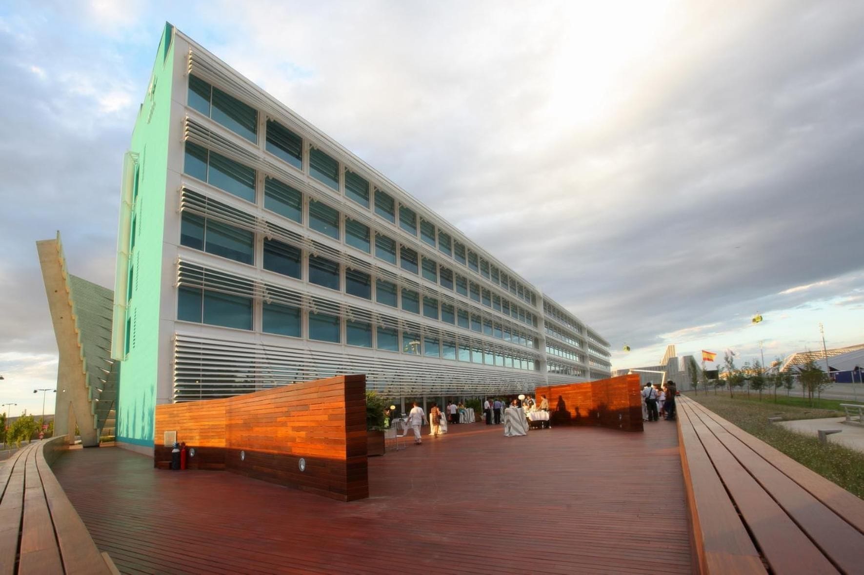 A modern building with a glass facade and a wooden deck area.
