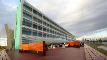 A modern building with a glass facade and a wooden deck area.