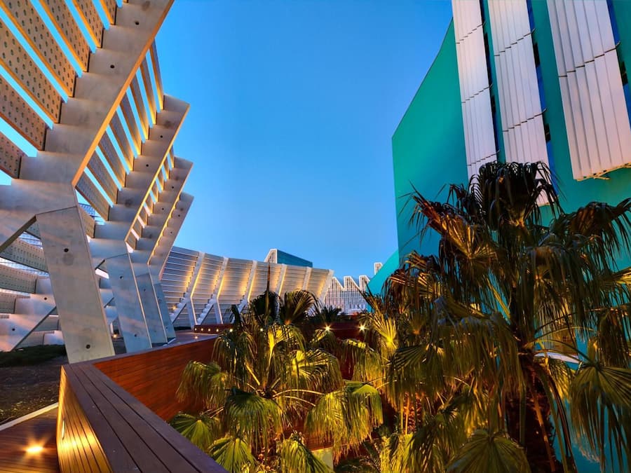 Una estructura arquitectónica moderna con una serie de escaleras interconectadas y un edificio grande con ventanales verticales.