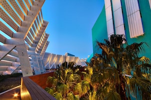 A modern architectural structure with a series of interconnected staircases and a large building with vertical windows.