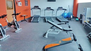 A gym with treadmills, a stationary bike, and exercise balls. - Sand Diamond Hotel (Colon)