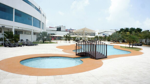 A pool area with lounge chairs and a covered seating area. - Sand Diamond Hotel (Colon)