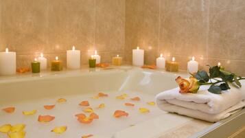 Una bañera con pétalos de rosa y velas, evocando un ambiente de spa.