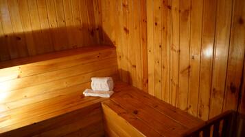 A wooden sauna with benches and a towel on one of the benches.