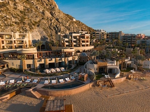 A resort with multiple buildings, a swimming pool, and a beach area.