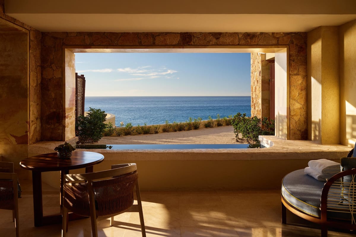Una habitación con vista al mar, una mesa y una silla.