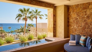 Una habitación con vista al océano, piscina y zona de estar también con vista.