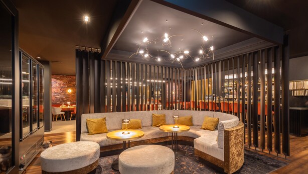 Un interior moderno con un sofá modular, otomanas y una zona de comedor.