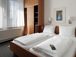 Ropa de cama hipoalergénica y caja de seguridad en la habitación 