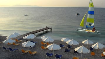 Aan het strand, ligstoelen aan het strand, parasols, waterskiën