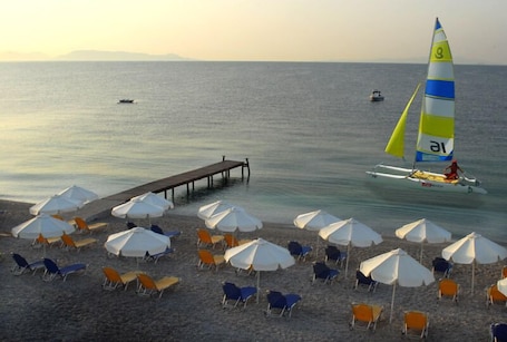 On the beach, sun loungers, beach umbrellas, water skiing. Comer Kinetta Beach