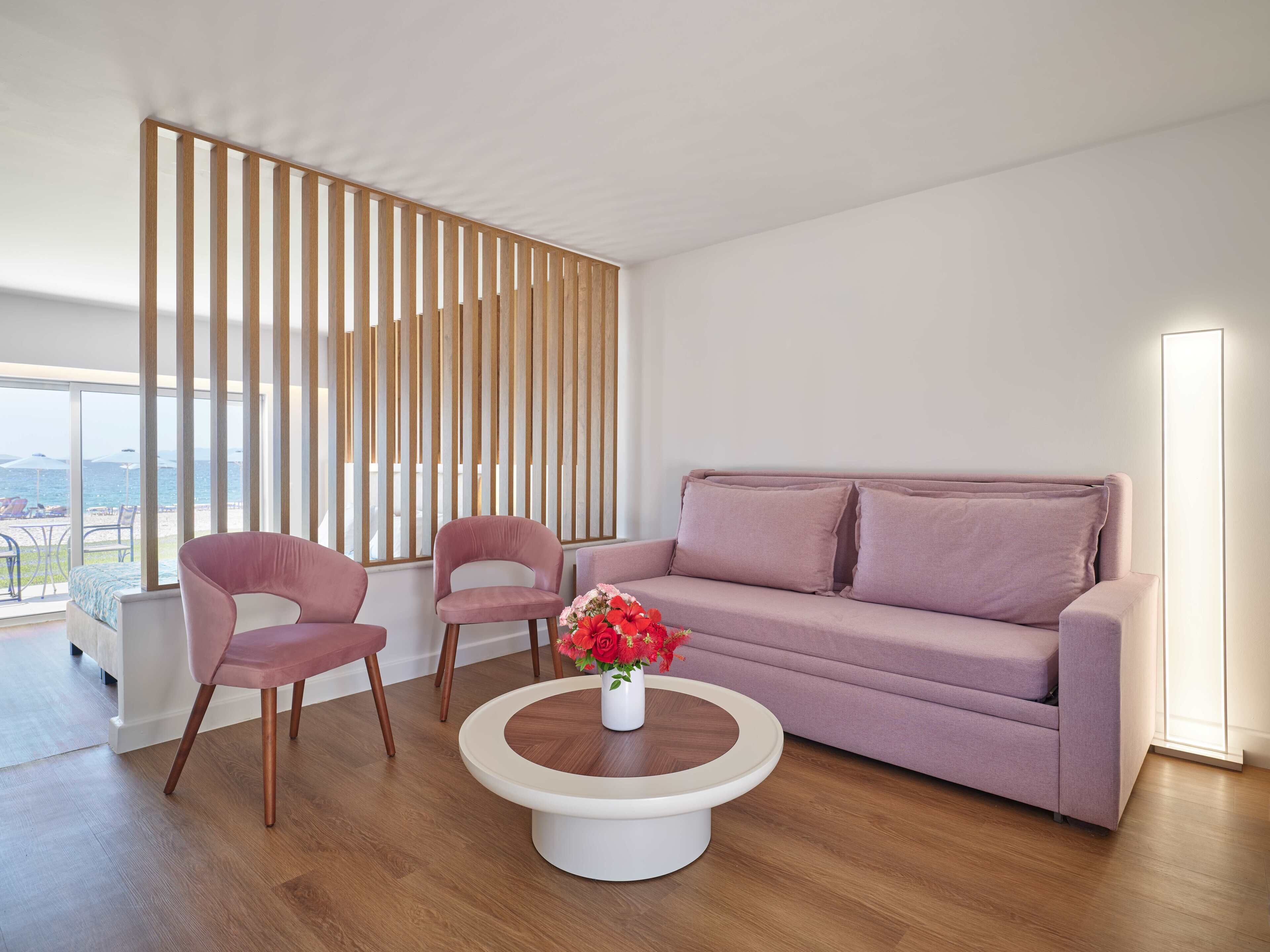 Una sala de estar moderna con un sofá, dos sillones, una mesa de centro y un panel de madera decorativo.