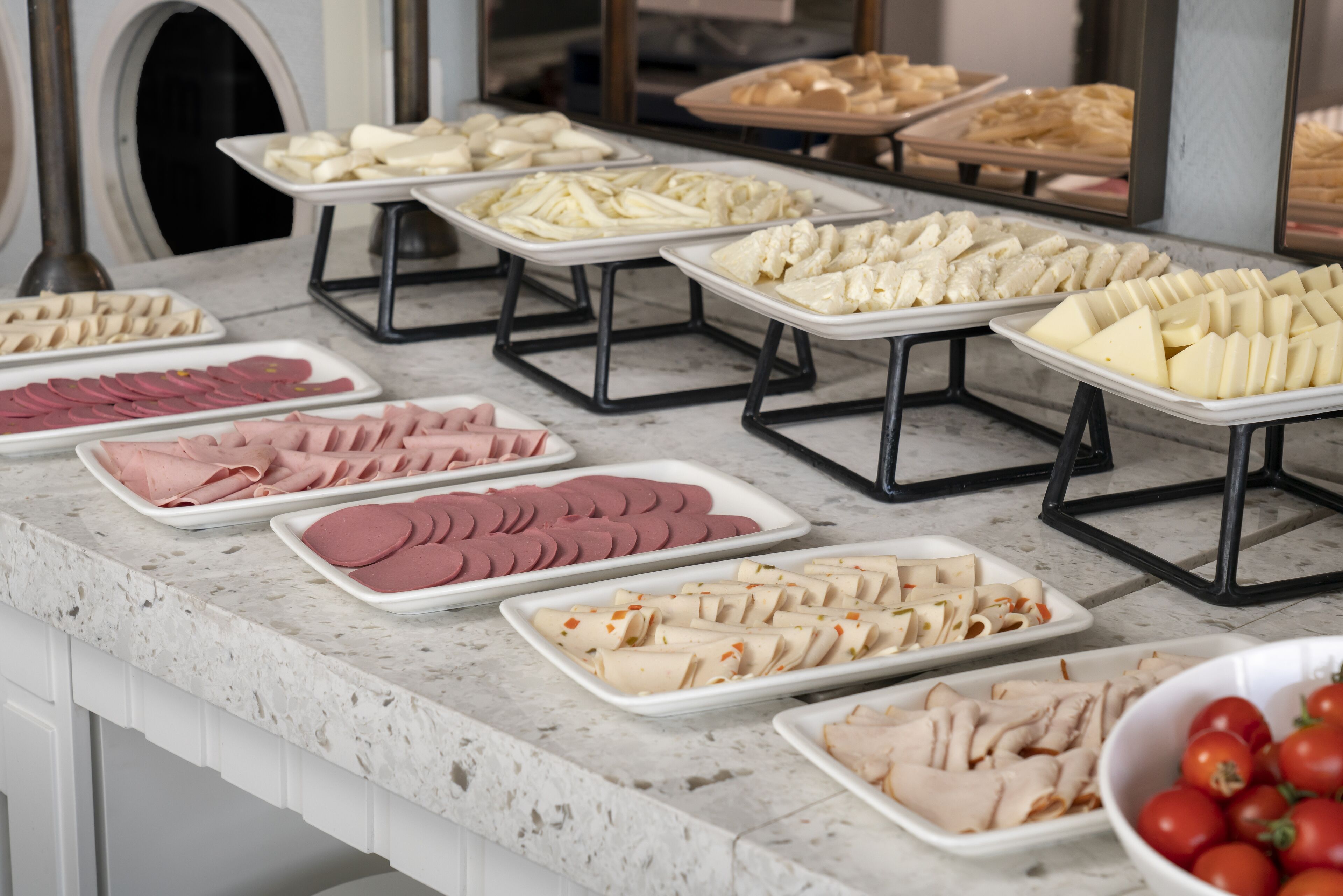 Un buffet proposant une variété de plats, notamment des viandes, des fromages et des fruits.